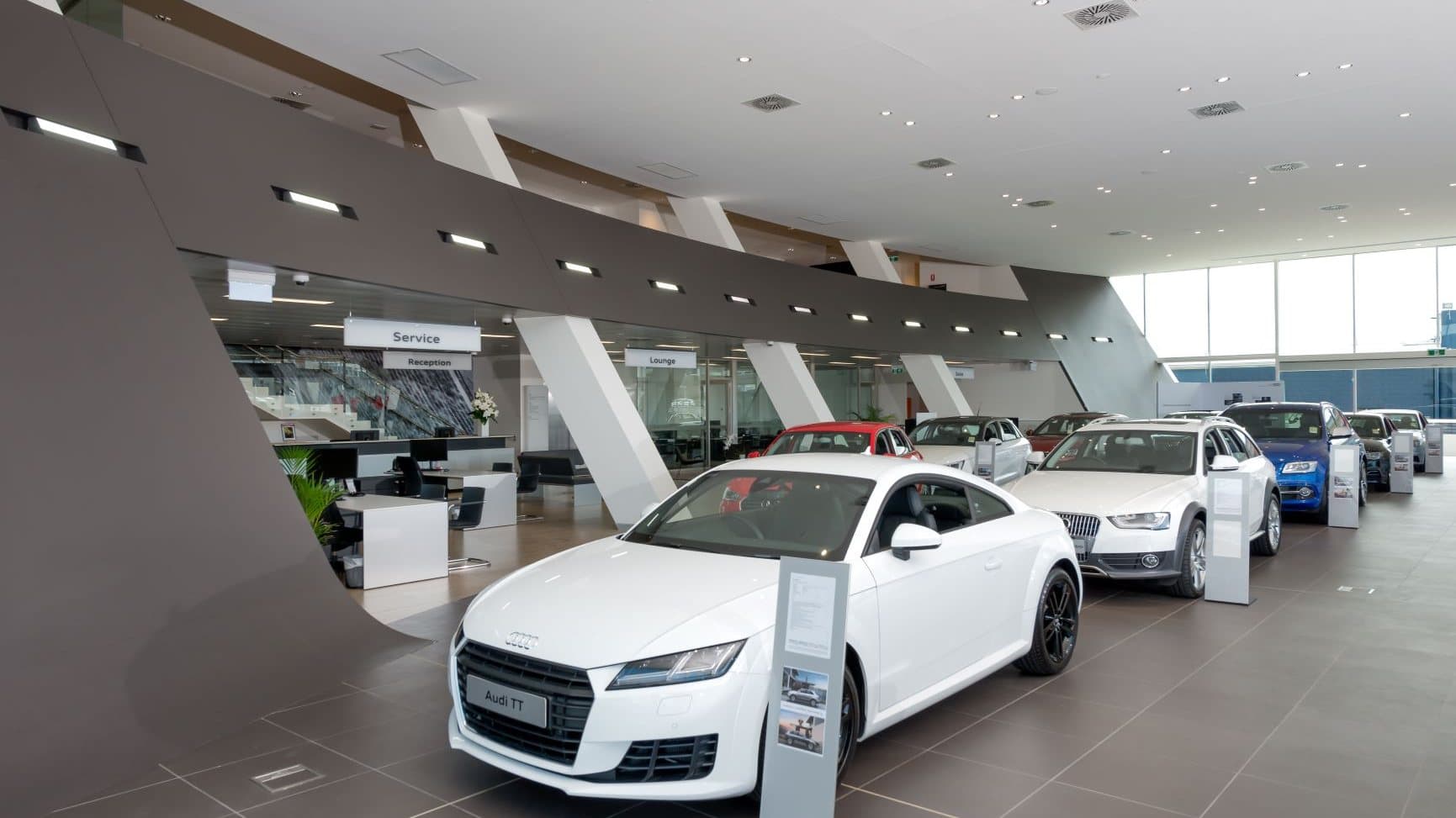 New vehicles lined up on a dealership showroom floor